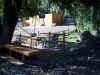 Bench and deck overlooking creek under a willow tree